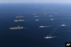 Three U.S. aircraft carriers USS Nimitz, left top, USS Ronald Reagan, left center, and USS Theodore Roosevelt, left bottom, participate with other U.S. and South Korean navy ships during the joint naval exercises between the United States and South Korea.