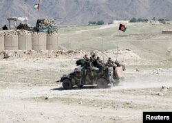 FILE - Afghan special forces patrol in Pandola village near the site of a U.S. bombing in the Achin district of Nangarhar province in eastern Afghanistan, April 14, 2017.