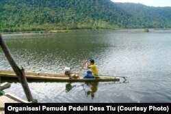 Nelayan tradisional sedang mengayuh perahu di atas permukaan Air danau Tiu yang masih jernih, 2 Januari 2013. (Foto: Organisasi Pemuda Peduli Desa Tiu)