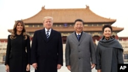 President Donald Trump, first lady Melania Trump, left, Chinese President Xi Jinping, second right, and his wife Peng Liyuan, right, stand together as they tour the Forbidden City, Nov. 8, 2017, in Beijing.