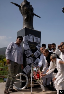 Pakistani journalists lay a wreath at a monument to pay tribute to journalists who lost their lives in the line of duty on the occasion of World Press Freedom Day at National Press Club in Islamabad, Pakistan, May 3, 2018.