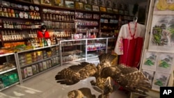 FILE - A North Korean woman stands behind the counter at a souvenir shop in Rajin, North Korea, inside the Rason Special Economic Zone. North Korea recently laid out new laws to facilitate foreign tourism and investment.
