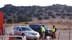 Security guards stand at the entrance to a film set where police say actor Alec Baldwin fired a prop gun, killing a cinematographer, outside Santa Fe, New Mexico, Oct. 22, 2021.