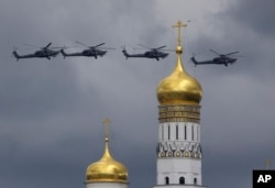 FILE - Russian military helicopters fly over Ivan the Great bell-tower and Moscow's Kremlin, May 9, 2016. A Washington-based think tank launched the Kleptocracy Archive, a database that enables users to “identify key actors in the complicated patronage and business networks that characterize kleptocracies."