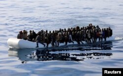 FILE - Migrants are seen in a rubber dinghy as they are rescued by the Libyan coast guard in the Mediterranean Sea off the coast of Libya, Jan. 15, 2018.