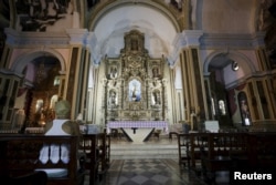 A woman sits in a Roman Catholic church in Havana, Sept. 17, 2015.