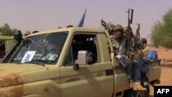 FILE - Members of an armed group sit in a vehicle in Kidal, Mali, July 13, 2016.