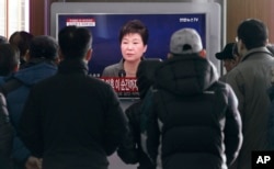 People watch a live broadcast of South Korean President Park Geun-hye addressing the nation at the Seoul Railway Station in Seoul, South Korea, Nov. 29, 2016.