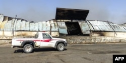 A pickup truck is parked next to a destroyed warehouse in an industrial district in the eastern outskirts of Yemen's port city of Hodeida, Nov. 18, 2018.