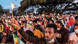 A man holds a candle during a memorial service for the victims of the Tigray conflict, organized by the city administration, in Addis Ababa, Ethiopia, on Nov. 3, 2021.