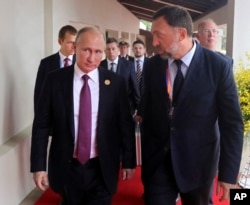 FILE - Russia's President Vladimir Putin (L) and Russian metals magnate Oleg Deripaska (R) walk to attend the APEC Business Advisory Council dialogue in Danang, Vietnam, Nov. 10, 2017.