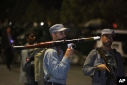 An Afghan policeman holds a rocket-propelled grenade launcher at the site of a complex Taliban attack on the campus of the American University in the Afghan capital Kabul on Wednesday, Aug. 24, 2016.