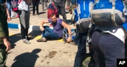 FILE - In this frame from video provided by Anapa Today, opposition leader Alexei Navally, center, tries to get up after being attacked at the Anapa airport, southern Russia, May 17, 2016.