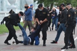 FILE - Belarus' security service agents and riot police officers detain an opposition supporter in Minsk on July 14, 2020, after the country's central electoral commission refused to register the main rivals to President Alexander Lukashenko as candidates for the country's presidential election in August.