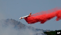 A heavy tanker drops retardant on a wildfire in Weber Canyon, Sept. 5, 2017, near Ogden, Utah.