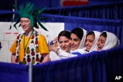 Team Afghanistan — from second from left, Kawsar Rashan, Lida Azizi, Somayeh Faruqi and Rodaba Noori — next to a member of Team Australia, at left, hug before their final round of competition at the FIRST Global Robotics Challenge, July 18, 2017, in Washington.