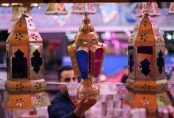 Seorang pria memeriksa lentera Ramadhan tradisional, yang disebut "fanous", di sebuah kios toko menjelang bulan suci Ramadhan, di tengah pandemi COVID-19 di Kairo, Mesir, 8 April 2021. (Foto: REUTERS/Mohamed Abd El Ghany)