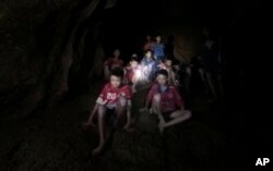 Na ovoj fotografili od 2. jula, koju je objavio Tam Luang centar za spasavanje, vide se dečaci i njihov fudbalski trener koji su pronađeni u delimično potopljenoj pećini, u Mae Seiu, Čiang Rai, Tajland