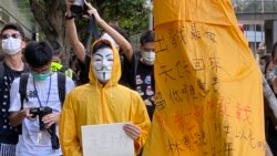 化名V的年青人穿上樑凌傑死前的黃色雨衣，象徵與梁凌傑同樣為民主自由站出來抗爭。 (美國之音湯惠芸)