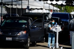 Para nakes menunggu di mobil untuk menjalani vaksinasi COVID-19 di San Diego, California (dok: AP/Gregory Bull)