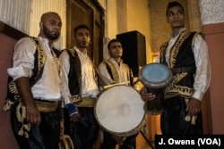 A group of drummers wait in the wings.