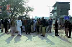 Petugas polisi mengendalikan massa yang marah memprotes seorang pria yang tidak stabil secara mental yang dituduh melakukan penistaan, di Mandani, daerah distrik Charsadda, Pakistan, 29 November 2021. (Foto: AP)