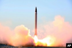This picture released by the official website of the Iranian Defense Ministry on Sunday, Oct. 11, 2015, claims to show the launching of an Emad long-range ballistic surface-to-surface missile in an undisclosed location. Iran successfully test fired a new