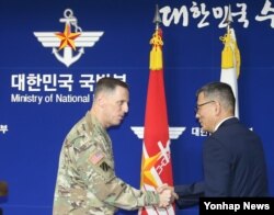 토머스 벤달 미8군사령관(왼쪽)과 류제승 힌극 국방부 국방정책실장이 8일 서울 국방부에서 주한미군의 고고도 미사일방어체계인 사드(THAAD) 배치 결정을 발표한 뒤 악수하고 있다.