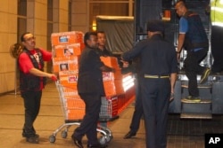 Para petugas kepolisian memasukkan barang-barang yang disita dari kediaman mantan Perdana Menteri Malaysia Najib Razak, ke dalam truk, di Kuala Lumpur, 18 Mei 2018.