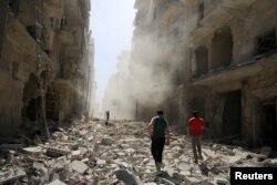 Men inspect the damage after an airstrike on the rebel held al-Qaterji neighborhood of Aleppo, Syria, Sept. 25, 2016.