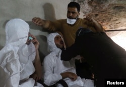 Čovek diše kroz masku s kiseonikom, dok se drugome priža pomoć, nakon onoga što su spasioci opisali kao napad gasom u gradu Kan Šeikun u pobunjeničkoj oblasti Idlib, Sirija, 4. aprila 2017.