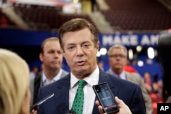 FILE - Trump Campaign Chairman Paul Manafort talks to reporters on the floor of the Republican National Convention at Quicken Loans Arena, July 17, 2016, in Cleveland.