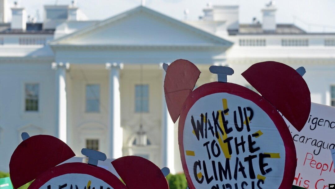 FILE - Protesters gather outside the White House in Washington to protest President Donald Trump's decision to withdraw the United States from the Paris climate change accord, June 1, 2017.