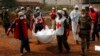 Local Red Cross workers move bodies from a mass grave at a military camp in the 200 villas neighborhood of Bangui, Feb. 17, 2014.