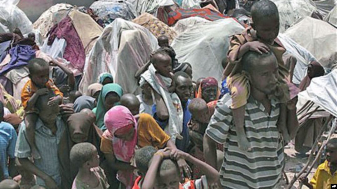 Somalis displaced by drought wait outside their makeshift shelters where tens of thousands have arrived in recent months desperately seeking food, water, shelter and other assistance, in Mogadishu, Somalia, July 25, 2011