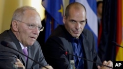 FILE - German Finance Minister Wolfgang Schaeuble (L) and Greek Finance Minister Yanis Varoufakis address the media during a joint press conference in Berlin, Germany, Feb. 5, 2015. 