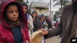 Perempuan dan anak-anak Palestina antre mendapatkan roti di Deir al-Balah, Jalur Gaza, Kamis, 28 November 2024. (Foto: Abdel Kareem Hana/AP Photo)