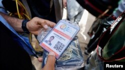 Seorang pria memegang kartu identitas pekerja bantuan Saifeddin Issam Ayad Abutaha, yang tewas dalam serangan Israel bersama dengan pekerja asing lainnya dari World Central Kitchen (WCK), di Rafah, Jalur Gaza selatan (foto: ilustrasi). 