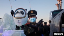 一名中國武警士兵在北京的冬奧會吉祥物前給拍照者做手勢。（2022年1月15日）