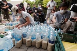 지난 18일 서울에서 탈북민 단체 회원들이 북한으로 보내려는 패트병에 쌀과 마스크를 담고 있다.