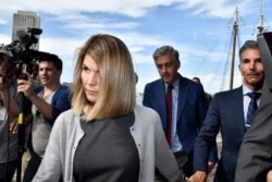 FILE - Actress Lori Loughlin, and her husband, fashion designer Mossimo Giannulli leave the federal courthouse after a hearing on charges in a nationwide college admissions cheating scheme in Boston, Massachusetts, Aug. 27, 2019.