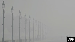 People walk along the Kartavya Path amid heavy smoggy conditions in New Delhi, Nov. 5, 2023.