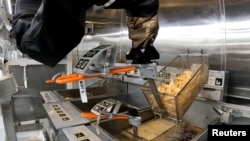 Robot Flippy 2 mengangkat kentang goreng dari tong minyak di laboratorium pabrik Miso Robotics Inc di Pasadena, California, AS 27 September 2022. (Sandra Stojanovic / REUTERS TV via REUTERS)