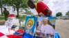 A vendor arranges portraits of Pope Francis outside of the Lubaga Cathedral in Kampala, Uganda, Nov. 13, 2015. 