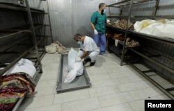 Orang-orang melihat jenazah warga Palestina yang tewas dalam serangan Israel, di kamar mayat Rumah Sakit Nasser, di Jalur Gaza selatan. (Foto: Reuters)