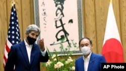 Utusan Iklim AS, John Kerry (kiri) dan PM Jepang Yoshihide Suga di Tokyo, 31 Agustus 2021. (Behrouz Mehri/Pool Photo via AP)
