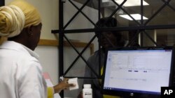 FILE - A woman receives her medication from a pharmacist at the Helen Joseph hospital, in Johannesburg, South Africa, Nov. 15, 2012.