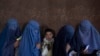 Sejumlah perempuan Afghanistan menunggu untuk menerima uang tunai oleh Program Pangan Dunia, di Kabul, Afghanistan, 20 November 2021. (Foto: AP/Petros Giannakouris)