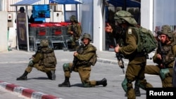 Soldados israelitas trabalham para proteger áreas residenciais após uma invasão em massa por homens armados do Hamas provenientes da Faixa de Gaza, em Sderot, 7 de outubro 2023