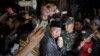 A protester raises his fist during an anti-communism rally outside the office of Legal Aid Institute early Sept. 18, 2017. A mob opposed to public discussion of Indonesia's 1965 massacre of communists tried to force its way into the building where they believed communists were meeting, injuring five policemen.